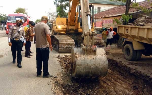 MEMANTAU: Kasatlantas Polres Kotim didampingi anggotanya saat sedang memantau kegiatan perbaikan jalan di Jalan Kapten Mulyono, Kamis (4/3) pagi.(HENY/RADAR SAMPIT)