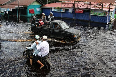 warga memanfaatkan jasa transportasi mobil bak terbuka untuk melintasi banjir yang merendam jalan trans kalimantan di desa tumbang nusa, pulang pisau, kalimantan tengah,